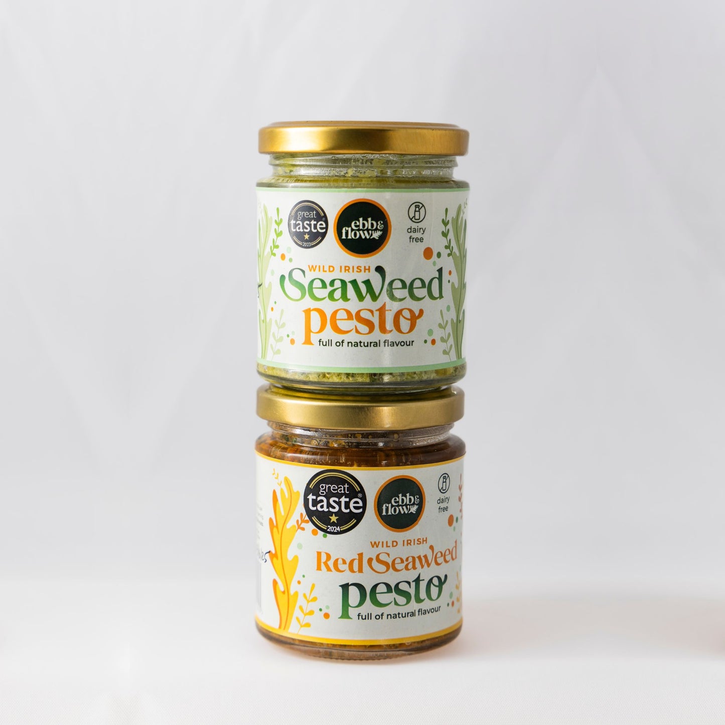 Two jars of Seaweed Pesto (one green and one red) on a white background